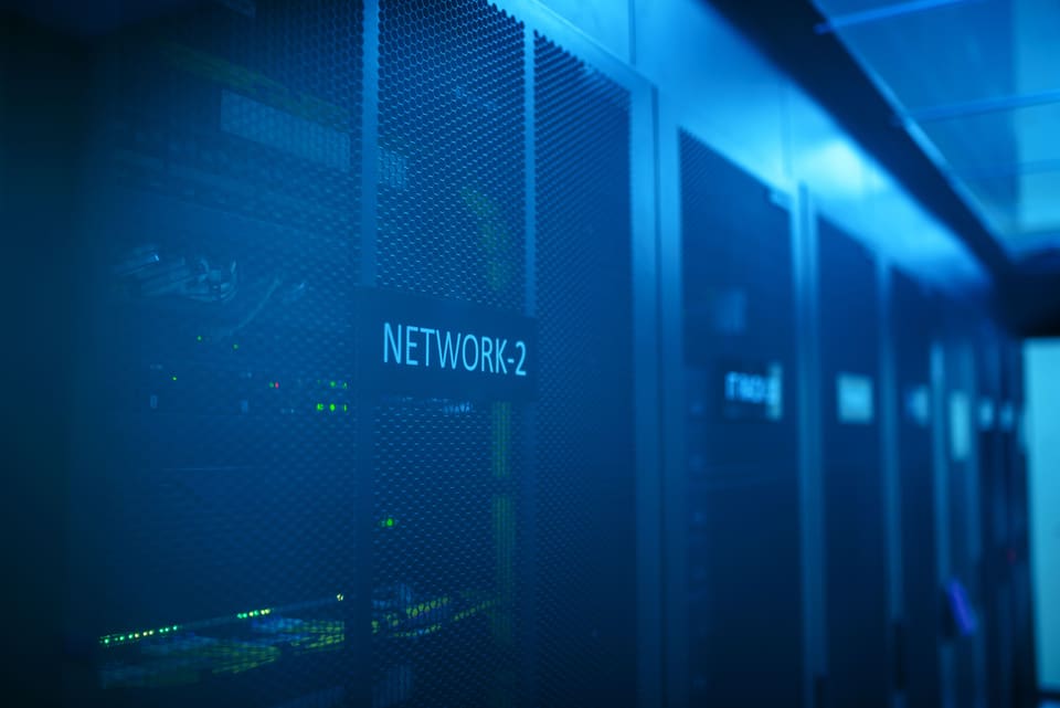 Serverraum-Korridor mit beschrifteten Rack-Einheiten in blauem Licht